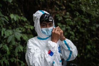 Edison Cosico, an administrative aide at the UPLB Museum of Natural History, secures his hazmat suit, in Los Banos, Laguna province, Philippines, on February 18, 2021.