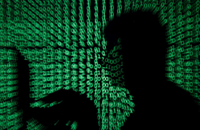 We are facing a digital moment of truth as a result of the new coronavirus. A man holds a laptop computer as cyber code is projected on him in this illustration and picture produced on May 13, 2017. the image shows the silhouette of a man on a laptop with green ones and zeroes, reminiscent of the film "The Matrix" projected over the image. REUTERS/Kacper Pempel/Illustration