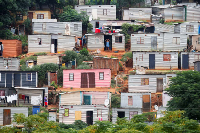 A general view of shacks during a nationwide twenty-one day pandemic lockdown in an attempt to contain coronavirus infections in Umlazi township near Durban, South Africa, on March 31, 2020. The photo shows a hillside covered with tin shacks, some colorfully painted. REUTERS/Rogan Ward 