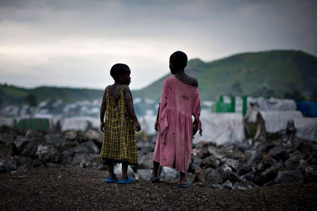 Congolese girls displaced by war stand on the outskirts of a makeshift camp near Goma in eastern Democratic Republic of Congo on February 11, 2009. The photo shows two girls standing on a hill overlooking a camp filled with white tents at sunset. REUTERS/Finbarr O'Reilly