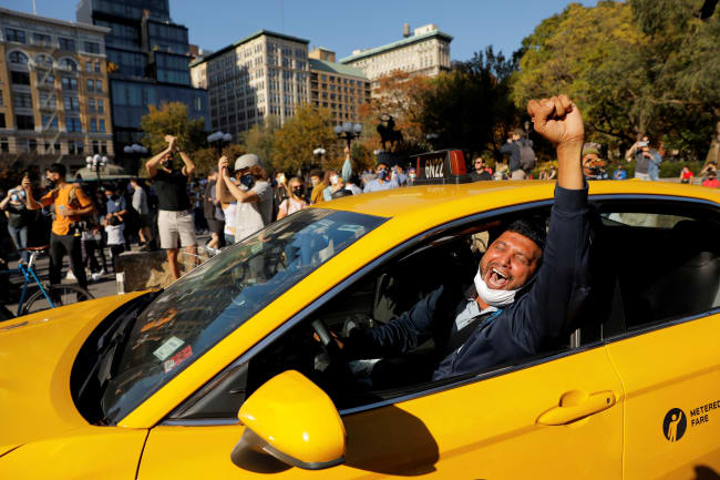 A cab driver raises his fist as people celebrate media announcements that Democratic U.S. presidential nominee Joe Biden has won the 2020 U.S. presidential election on Union Square in the Manhattan borough of New York City, U.S.