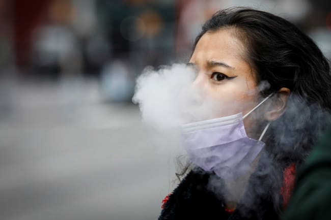 DOCUMENT DATE: April 01, 2020 A woman exhales after vaping in Times Square, during the coronavirus disease (COVID-19) outbreak, in New York City, U.S., March 31, 2020.
