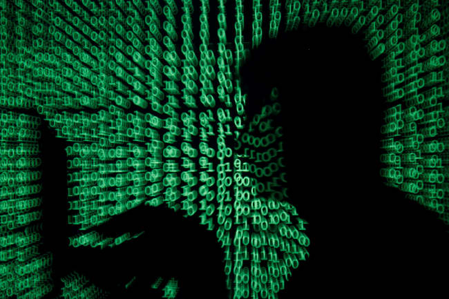 We are facing a digital moment of truth as a result of the new coronavirus. A man holds a laptop computer as cyber code is projected on him in this illustration and picture produced on May 13, 2017. the image shows the silhouette of a man on a laptop with green ones and zeroes, reminiscent of the film "The Matrix" projected over the image. REUTERS/Kacper Pempel/Illustration