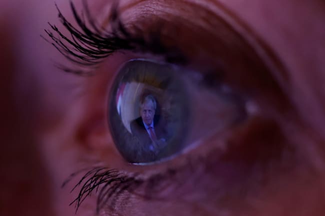 Britain's Prime Minister Boris Johnson is reflected in a woman's eye as she watches his address to the nation following the outbreak of coronavirus in Manchester, England, on September 22, 2020. The photo shows a macro lens image of an eye with the image of the PM reflected in it. REUTERS/Phil Noble