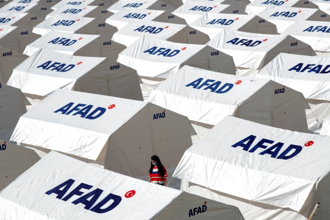 A woman walks amid a tent city set up by Turkey's Disaster and Emergency Management Presidency (AFAD) after an earthquake in the Aegean port city of Izmir, Turkey, November 1, 2020. 