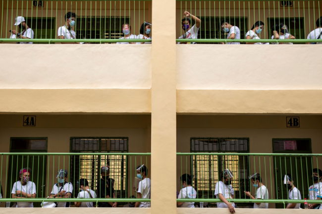 People whose jobs were affected by COVID-19 restrictions wait in lines to receive cash assistance from the government, at an elementary school in Quezon City, Metro Manila, Philippines, April 12, 2021.