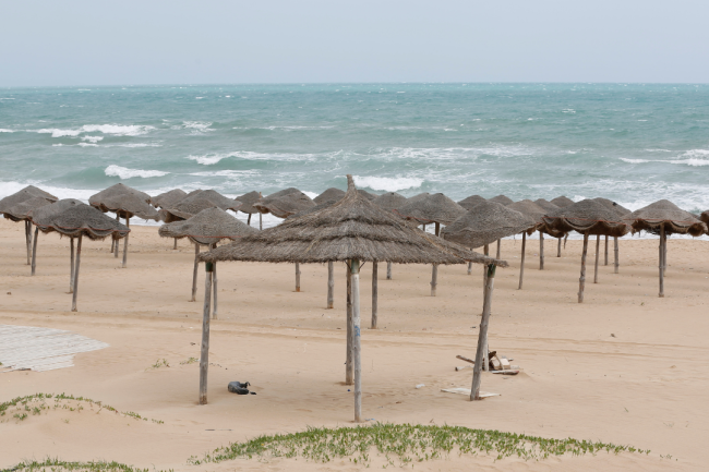 A deserted beach with umbrellas made of natural materials is pictured during an extended lockdown aimed at stemming the spread of COVID-19 in April 2020 in Tunis, Tunisia.