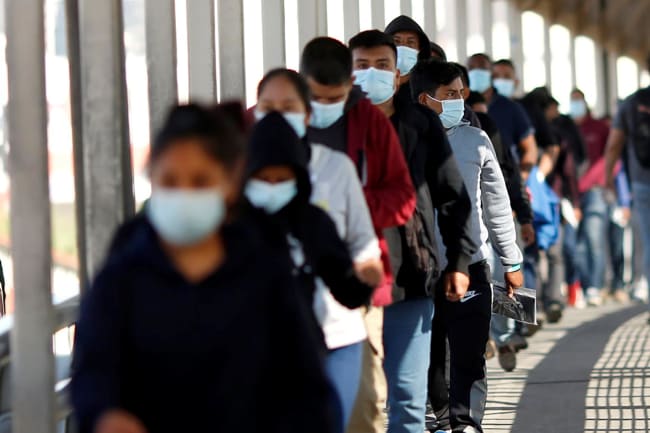 Migrants expelled from the U.S. and sent back to Mexico under Title 42, walk towards Mexico at the Paso del Norte International border bridge.