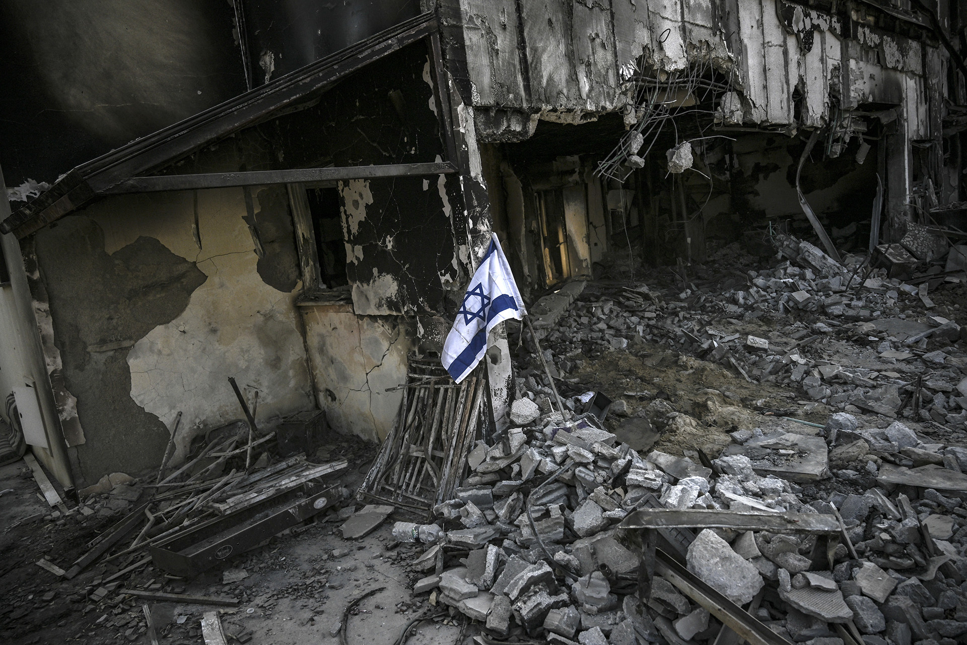 A picture shows an Israeli flag placed at a destroyed house in Kibbutz Beeri in southern Israel on November 5, 2023, nearly a month after the October 7 attack by Palestinian militants.