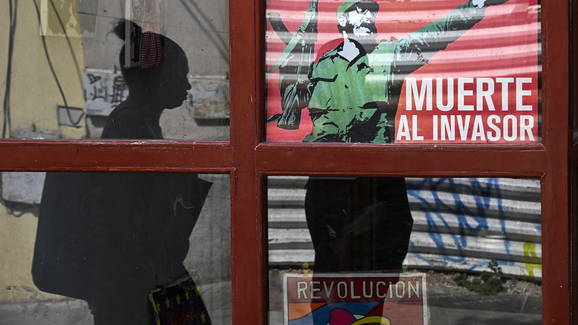 <p>A woman walks past a poster of late Cuban leader Fidel Castro reading, “Death to the invader” in Havana, on March 13, 2026.</p>
