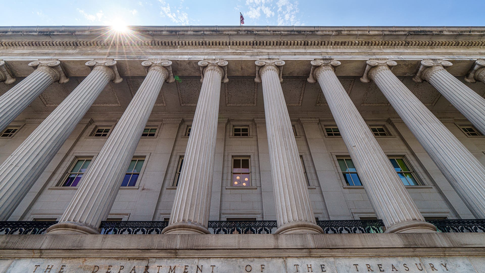 The sun flares over the top of the side entrance to the U.S. Treasury Department Building on August 18, 2024, in Washington, DC.