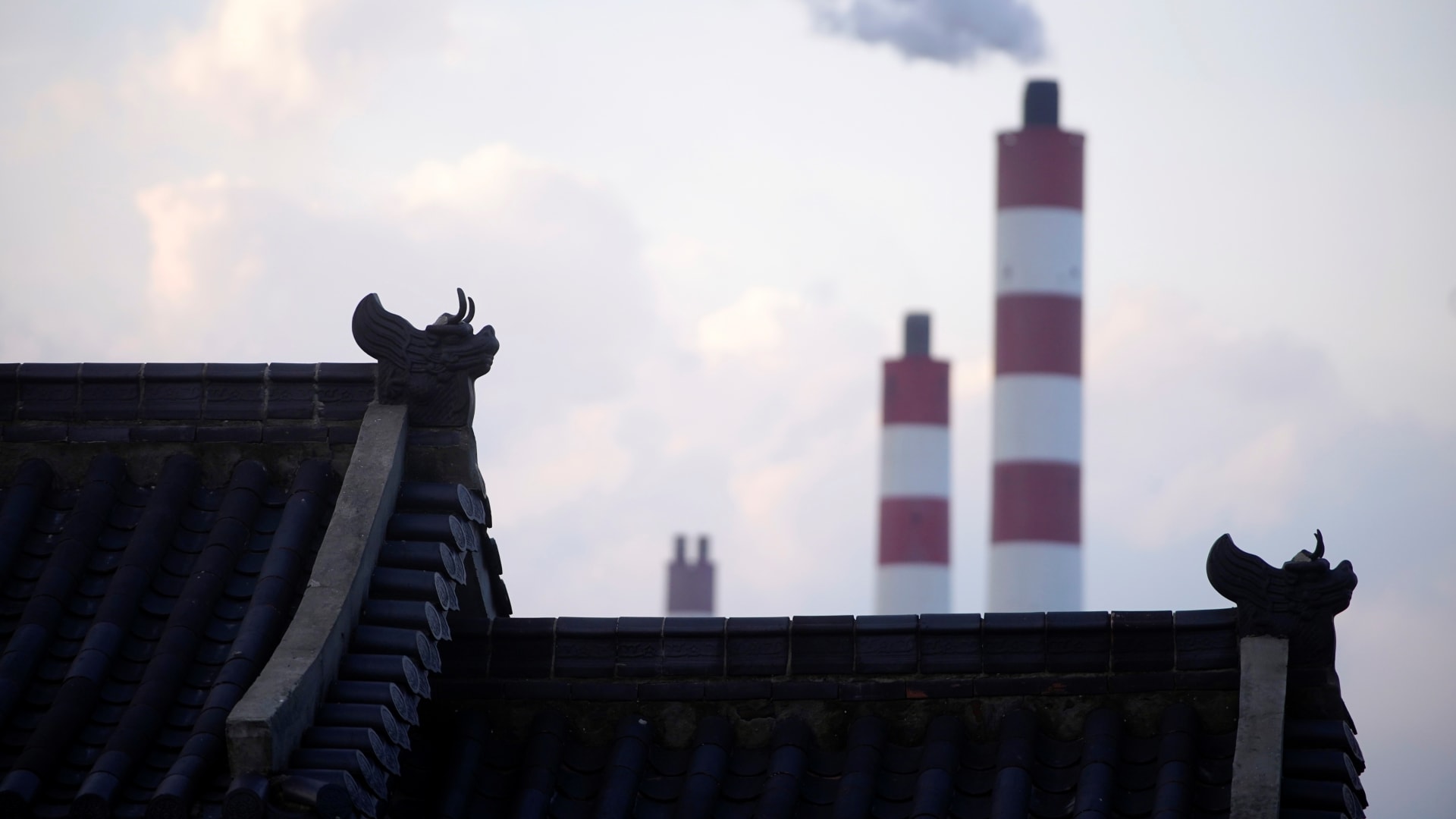 Chimneys of a coal-fired power plant are seen behind a gate in Shanghai, China October 21, 2021. REUTERS/Aly Song