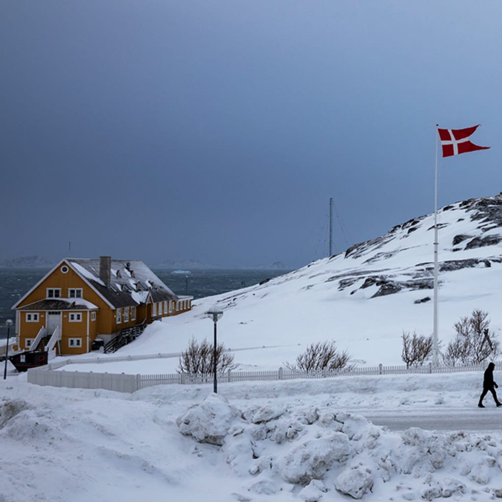 <p>A man passes a Danish flag ahead of Greenland’s general election in the island’s capital, Nuuk.</p>
