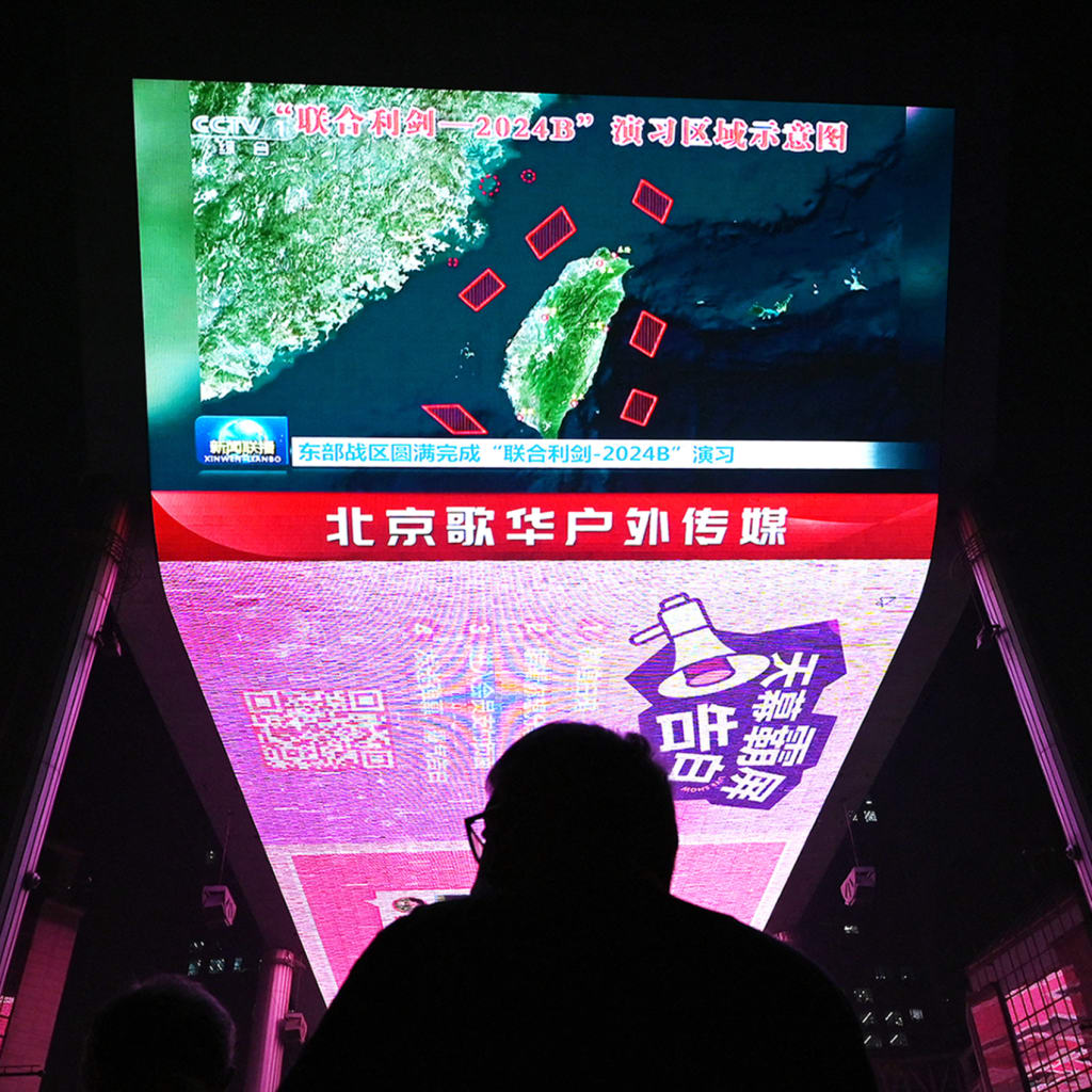 <p>A man in Beijing watches a news program about Chinese military drills surrounding Taiwan.</p>
