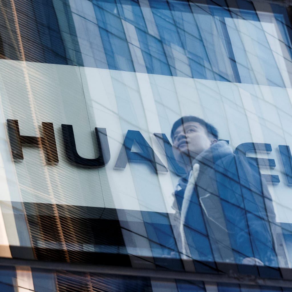 <p>A man walks past Huawei offices in Beijing.</p>
