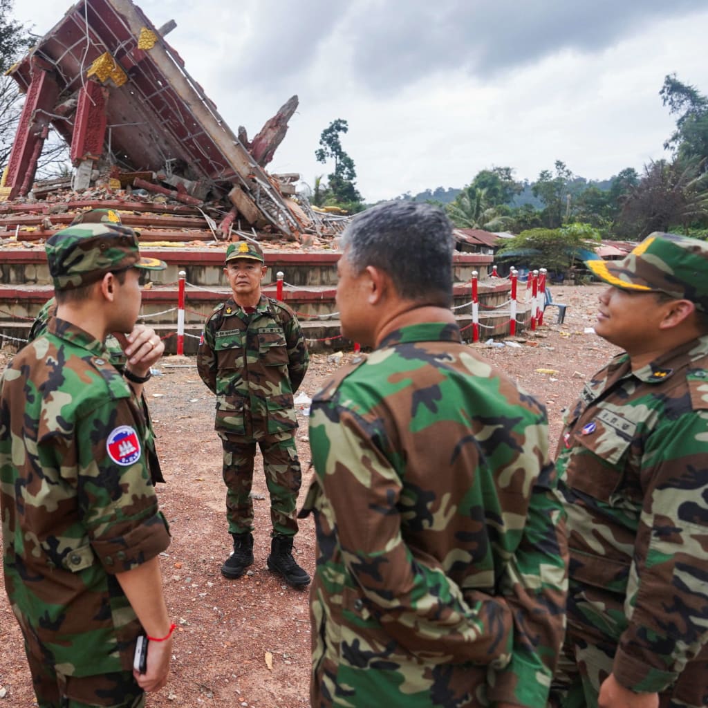 <p>Military personnel stand near a destroyed monument at the closed An Ses border checkpoint, also known as Chong Arn Ma in Thai, in Cambodia on August 4. </p>
