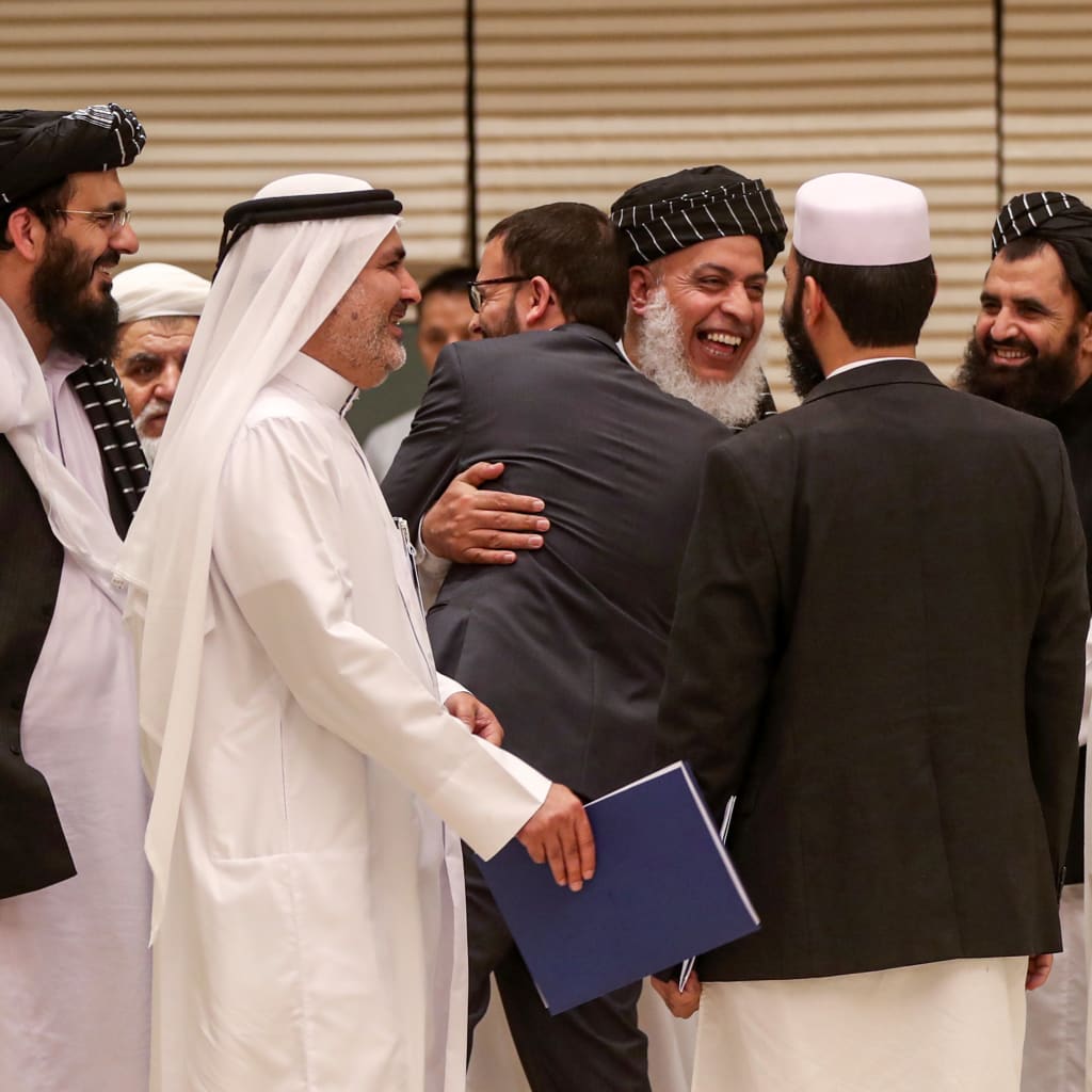 <p>Taliban negotiator Abbas Stanikzai embraces a man during the second day of the Intra Afghan Dialogue talks in Doha.</p>
