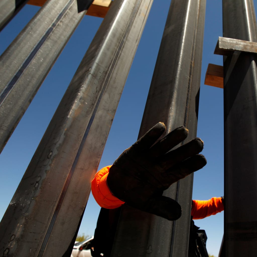 <p>A private security guard blocks the camera to avoid being photographed at a new section of the wall in Santa Teresa, New Mexico, April 23, 2018.</p>
