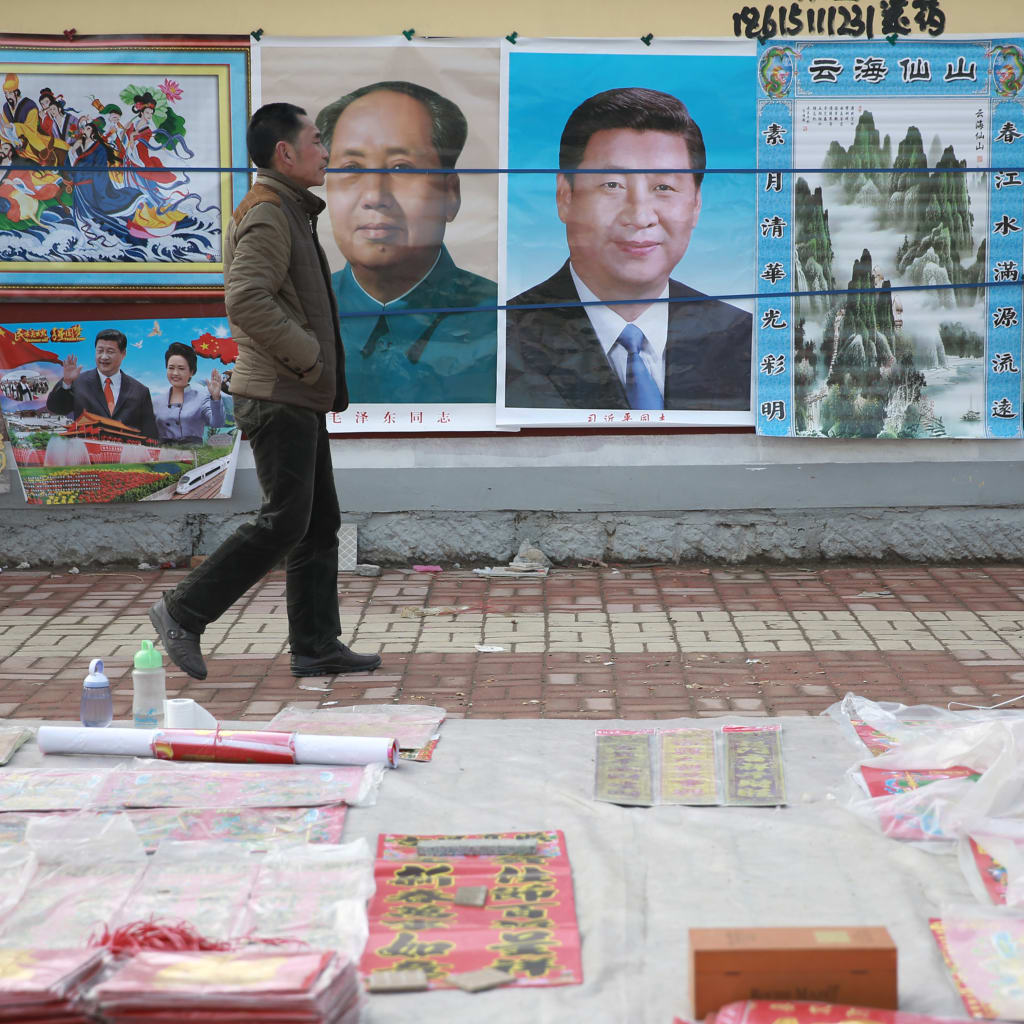 <p>A man walks past New Year decoration pictures featuring China’s President Xi Jinping, China’s late Chairman Mao Zedong and some other current senior officials, at a market in Juancheng, Shandong province, February 17, 2015. The Chinese Lunar New Year on F</p>
