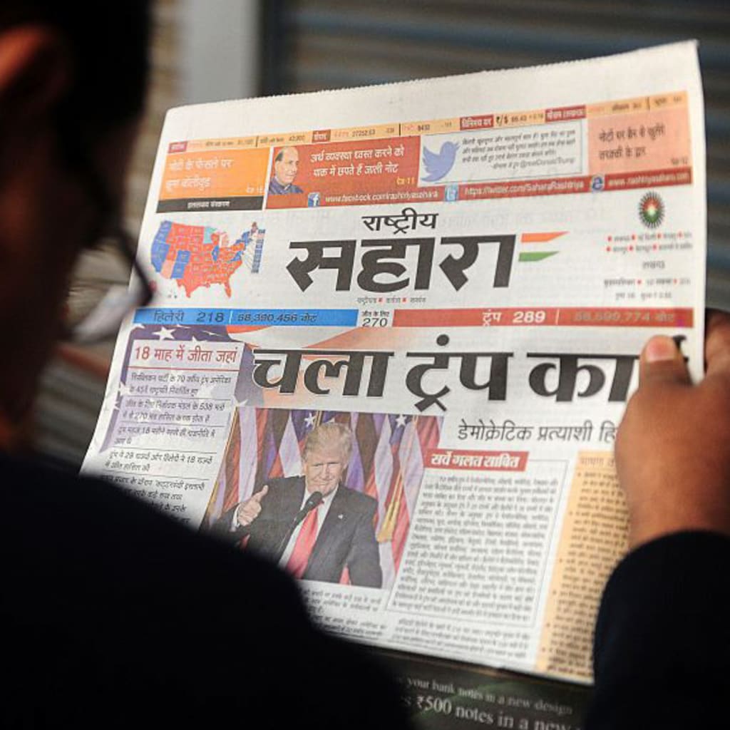 <p>An Indian man reads a newspaper article about newly elected U.S. President Donald J. Trump, on a street in Allahabad. </p>
