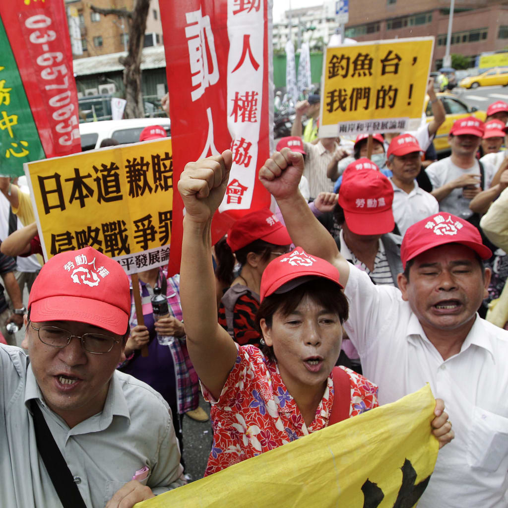 <p>Activists protest in front of the Japan-Taiwan Exchange Association in Taipei.</p>
