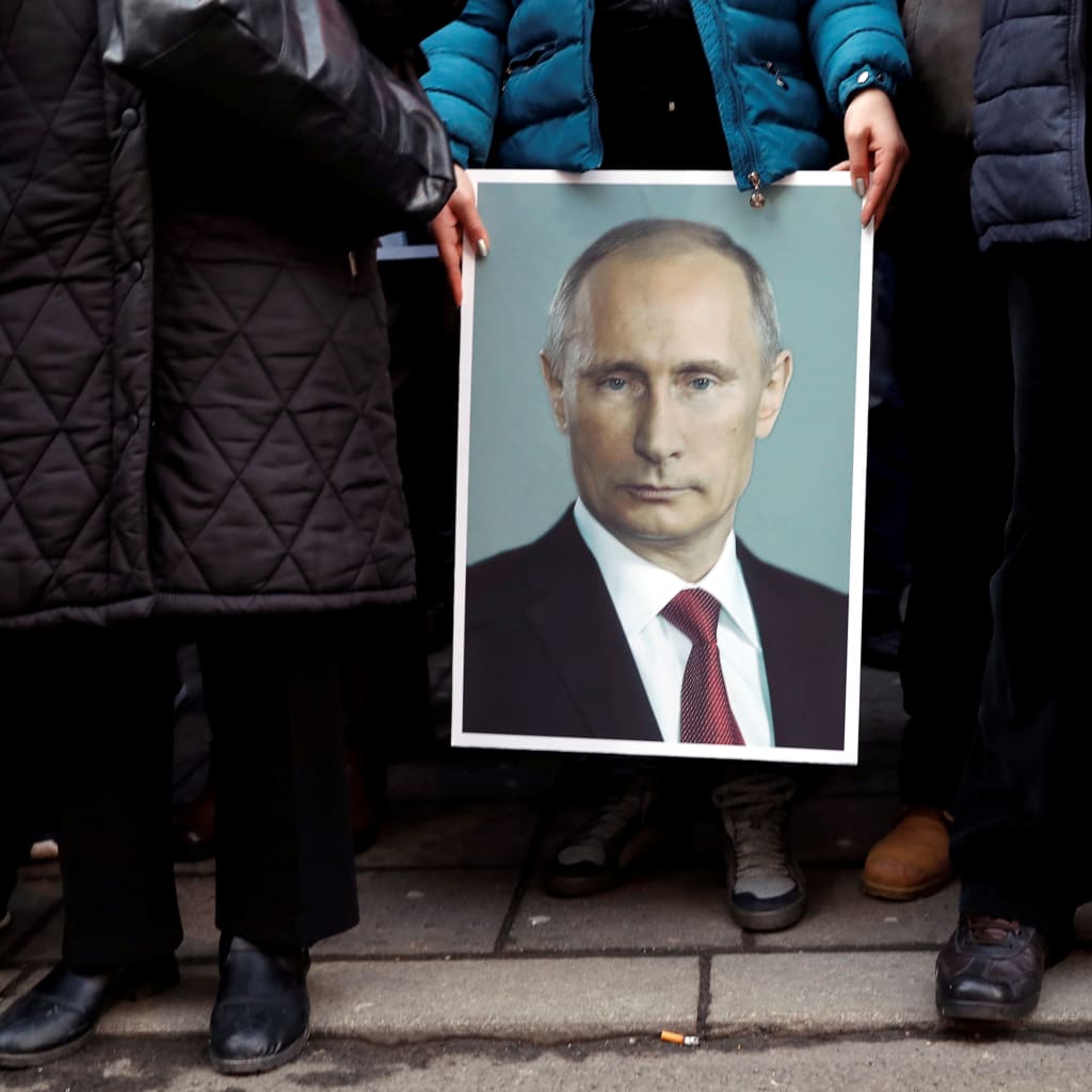 <p>A supporter of Russian President Vladimir Putin holds his portrait in Belgrade, Serbia, January 18, 2019.</p>
