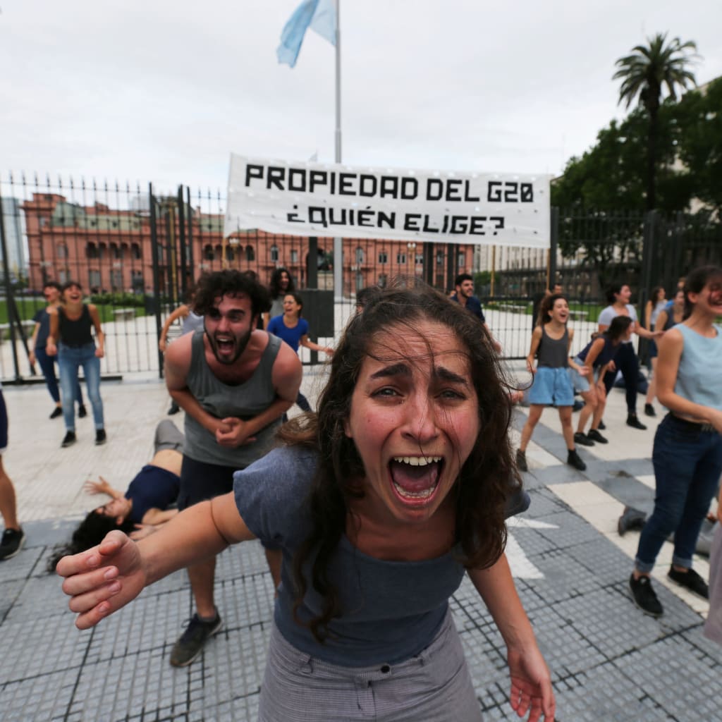 <p>Demonstrators perform outside the presidential palace, ahead of the Group 20 summit, in Buenos Aires, Argentina November 29, 2018. The writing on the banner reads “Property of the G20, who chooses?”</p>

