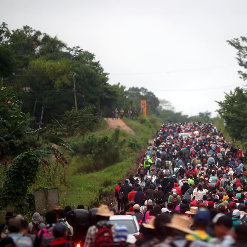 <p>Migrants, part of a caravan of thousands traveling from Central America en route to the United States, walk along the highway to Isla from Sayula de Aleman, Mexico, November 3, 2018. </p>
