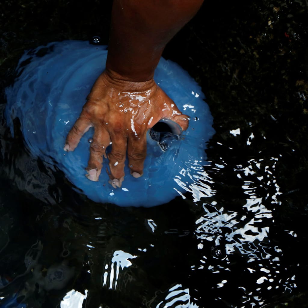 <p>People fill plastic containers with water in a well on the street, close to a neighbourhood called “The Tank” at the slum of Petare in Caracas, Venezuela, April 3, 2016.</p>
