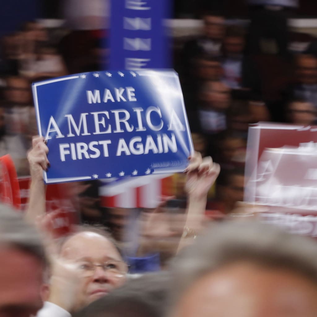 <p>A delegate waves a “Make America First Again” sign on the floor during the third session of the Republican National Convention in Cleveland, Ohio, U.S. July 20, 2016.</p>
