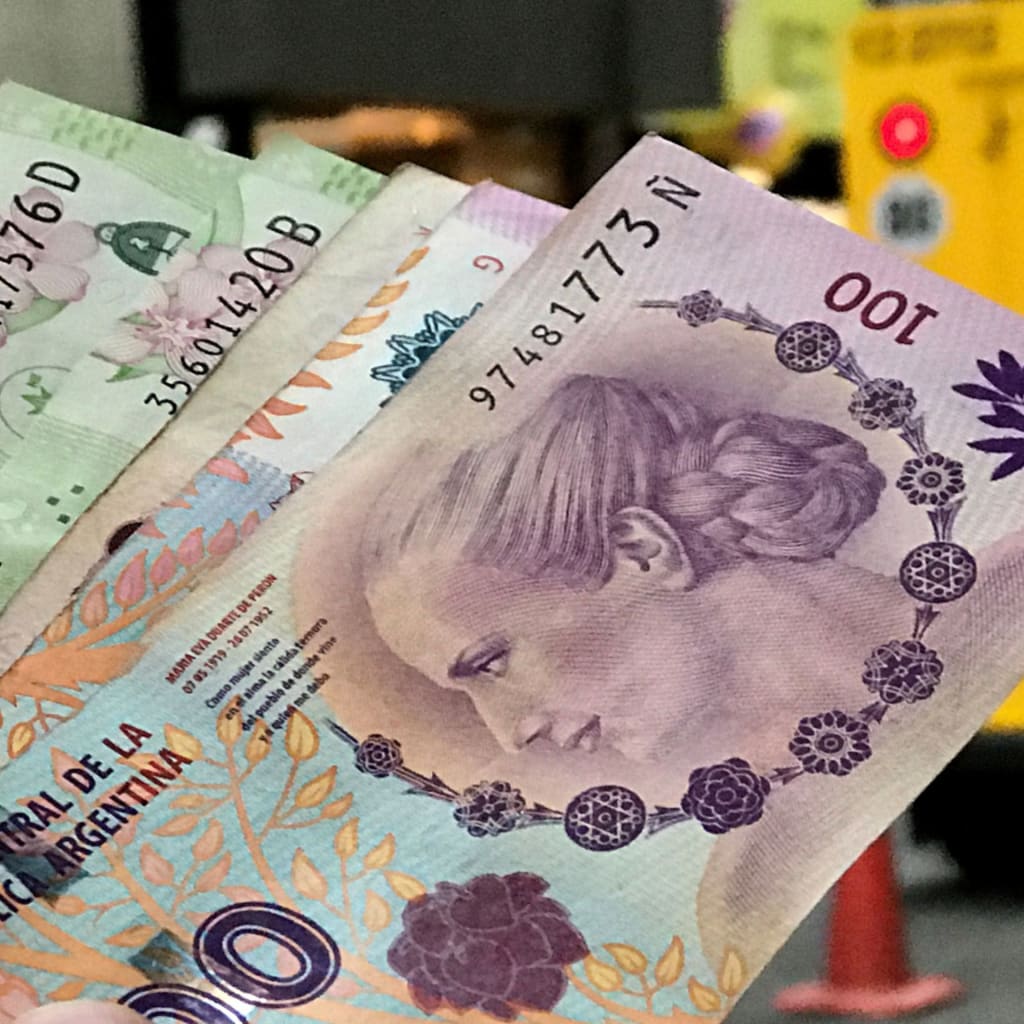 <p>A man shows Argentine pesos outside a bank in Buenos Aires’ financial district, August 30, 2018.</p>
