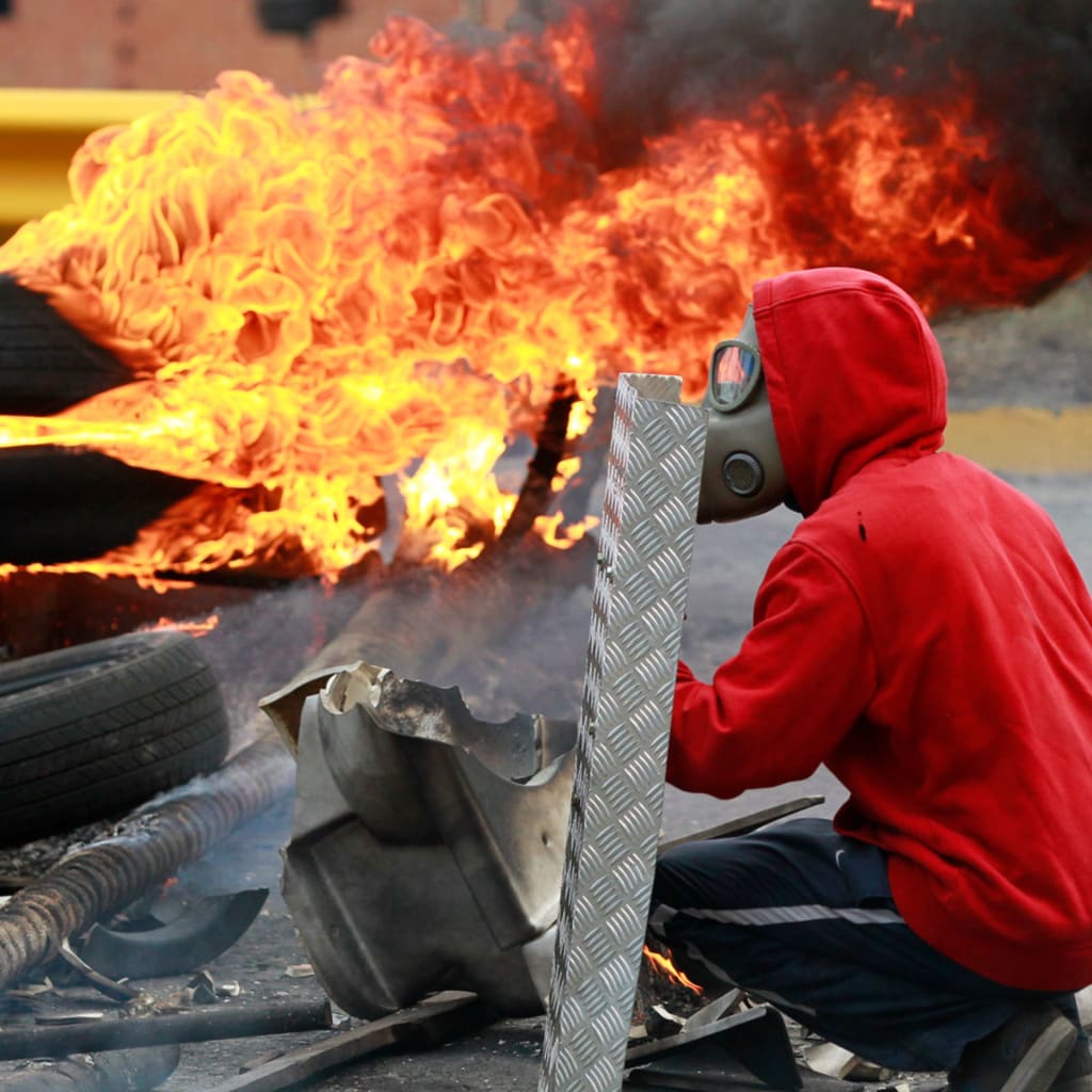 <p>An anti-government protester covers himself with a shield during a protest against President Nicolas Maduro’s government in Caracas June 4, 2014. </p>
