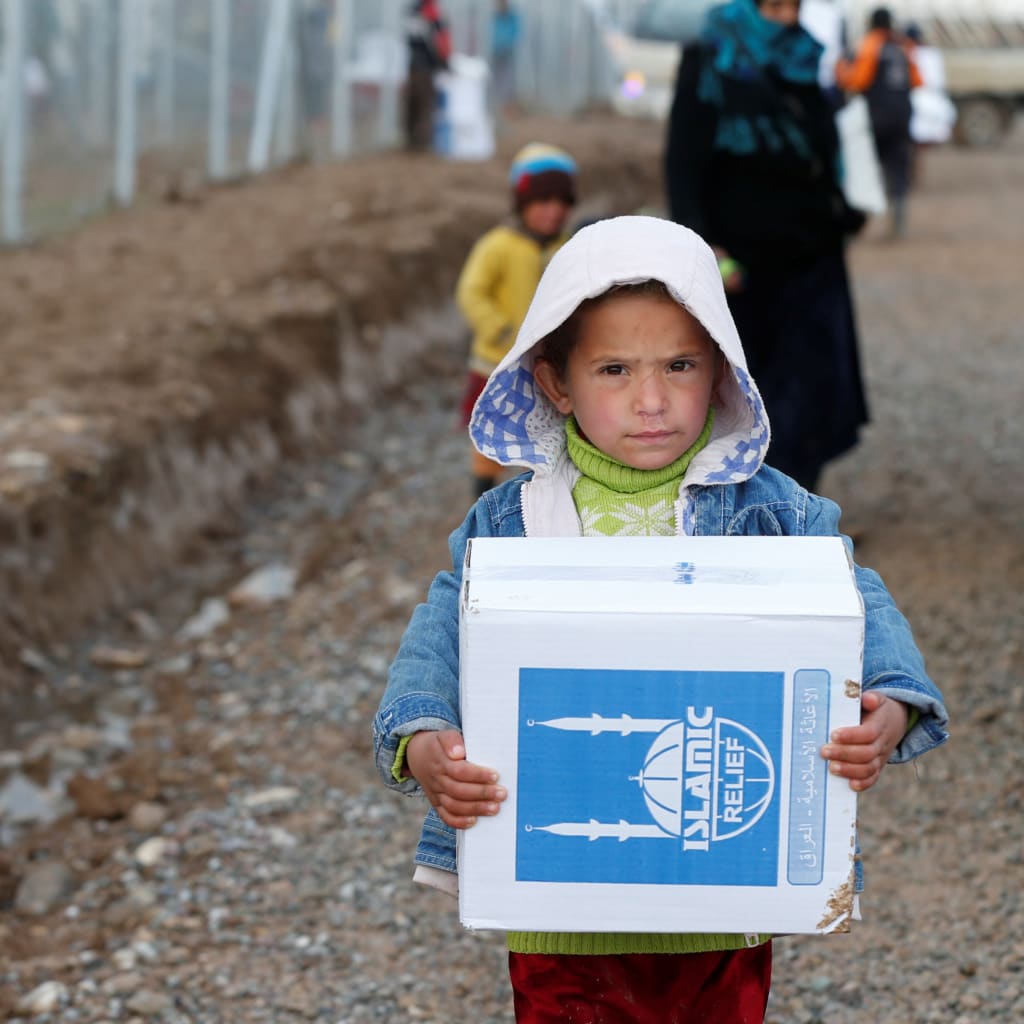 <p>A displaced Iraqi child who fled the Islamic State received humanitarian aid supplies at Al Khazer camp, Iraq.</p>
