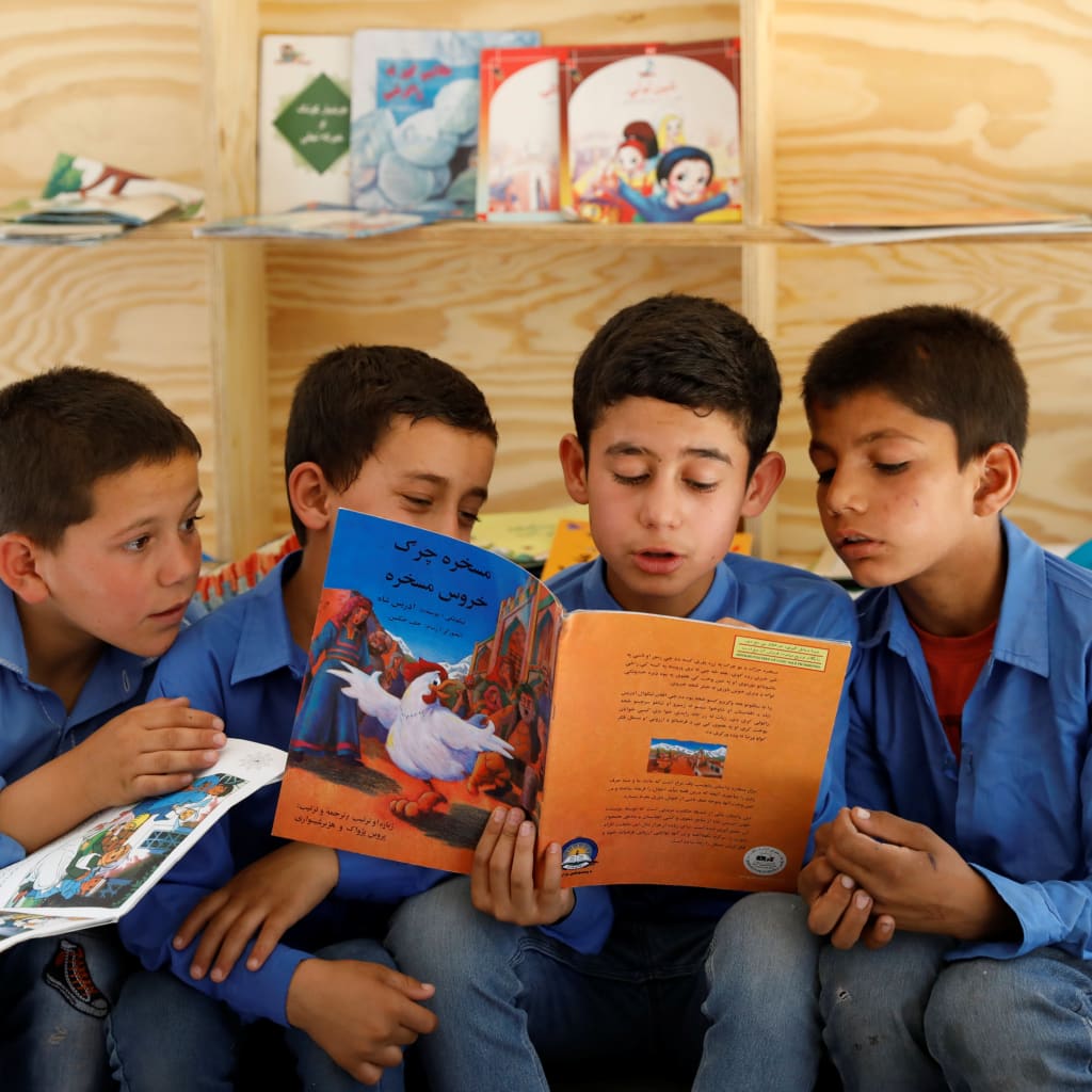 <p>Afghan boys reading inside a mobile library bus in Kabul, Afghanistan.</p>
