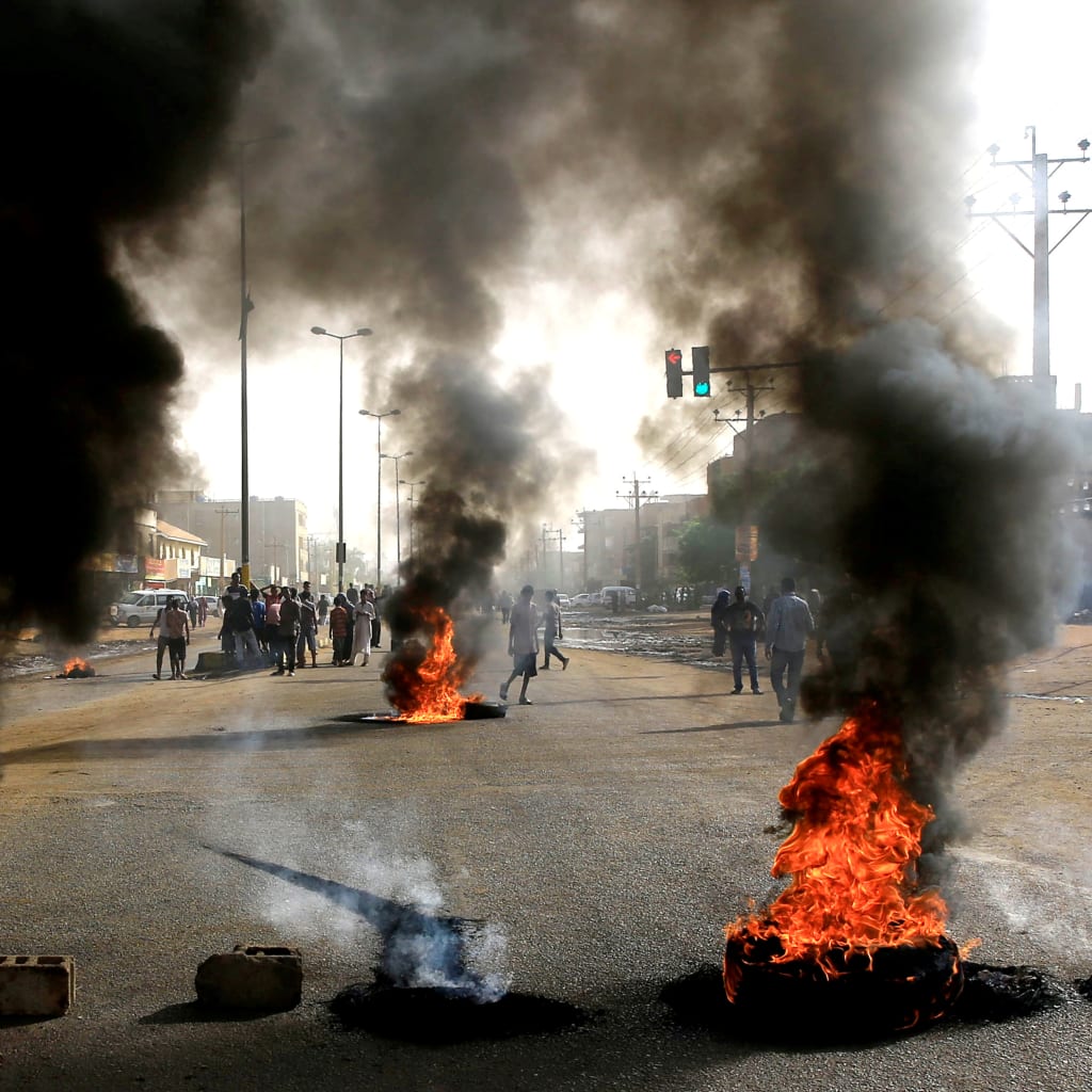 <p>Sudanese protesters use burning tires as a barricade in Khartoum.</p>
