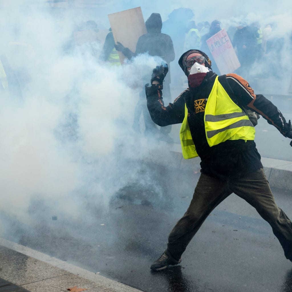 <p>A Yellow Vests protester throws a tear gas canister in Nantes, France.</p>
