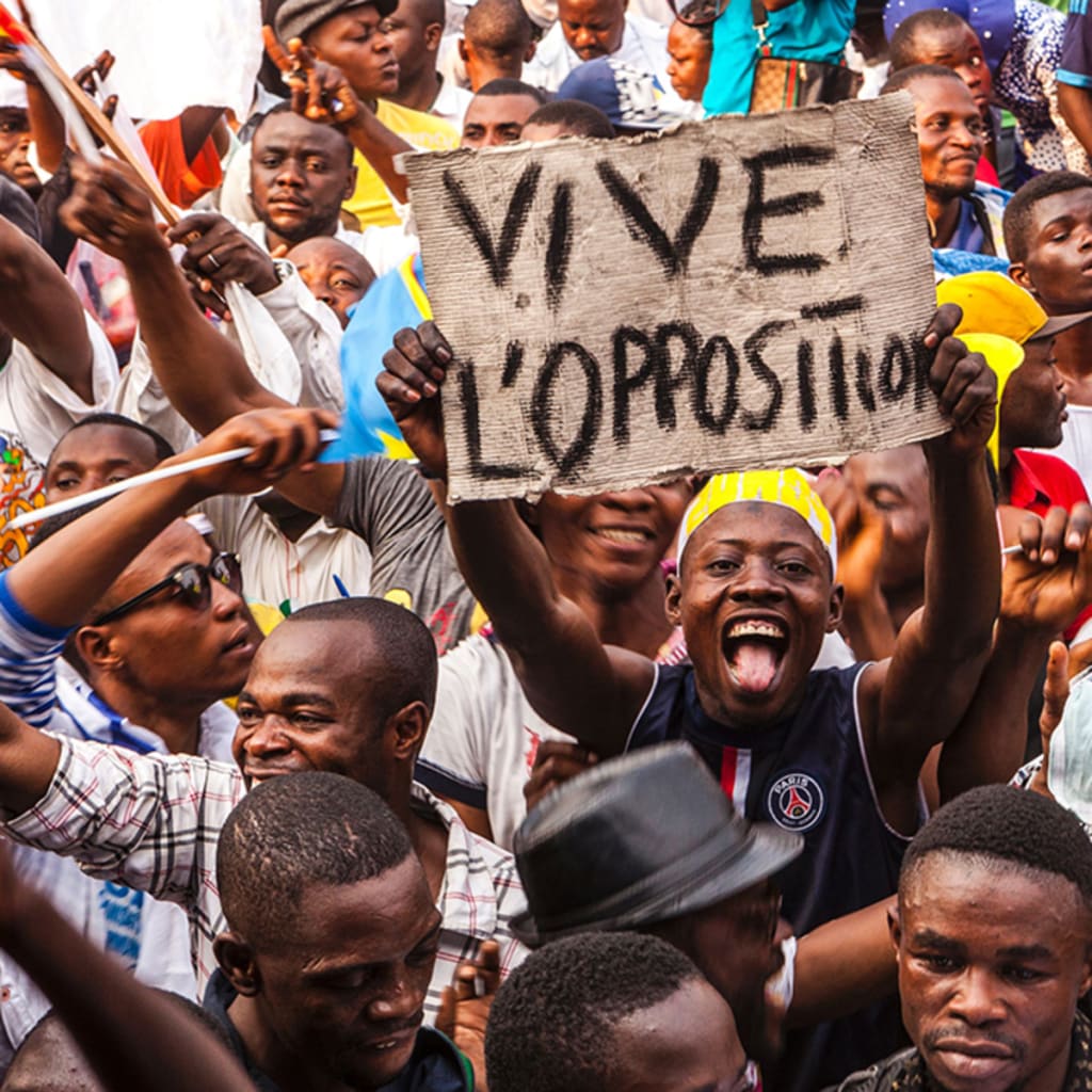 <p>An opposition supporter holds up a reading ‘Long live the opposition’ during a rally organised by political opposition parties in Kinshasa on July 31, 2016.</p>
