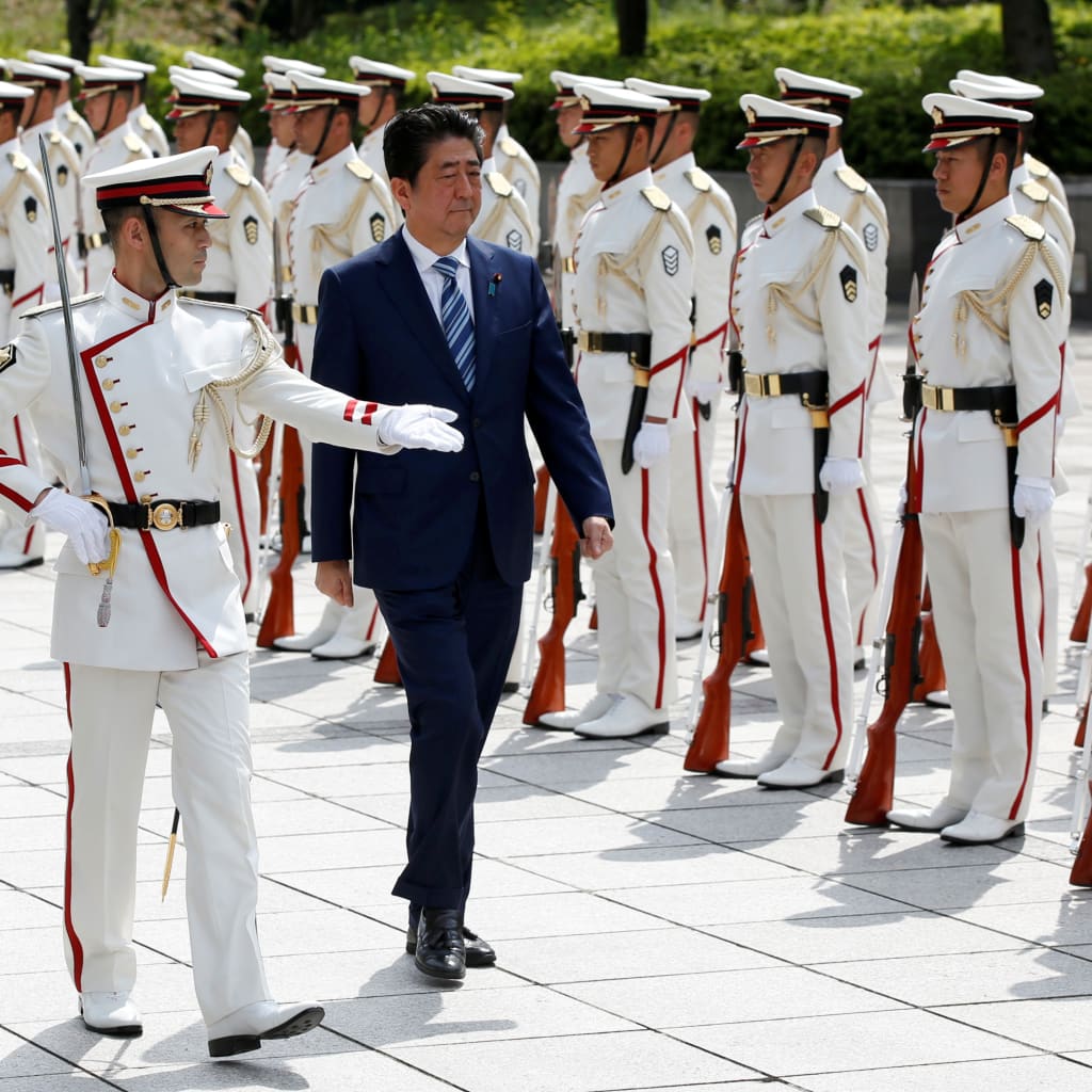 Japan's Prime Minister Shinzo Abe (R) and Defense Minister Itsunori Onodera (L) review the honour guard before a meeting with Japan Self-Defense Force's senior members at the Defense Ministry in Tokyo, Japan, September 11, 2017.