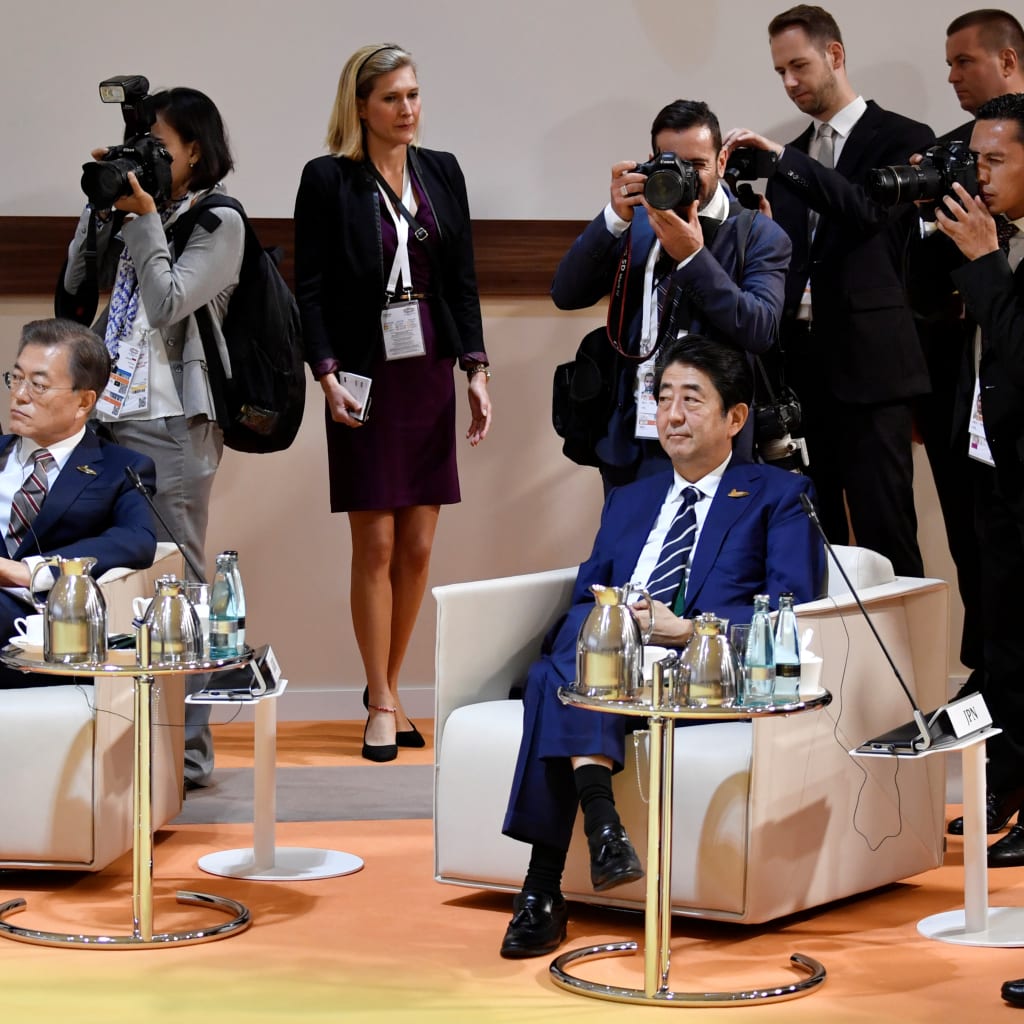 South Korea's President Moon Jae-in and Japan's Prime Minister Shinzo Abe sit at the start at the start of the "retreat meeting" on the first day of the G20 summit in Hamburg, Germany, July 7, 2017.