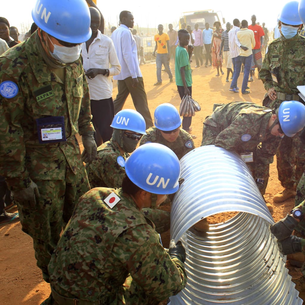 United Nations Mission in South Sudan peacekeepers from Japan assemble a drainage pipe at Tomping camp, where some 15,000 people who fled their homes following recent fighting are sheltered by the United Nations, in Juba January 7, 2014.