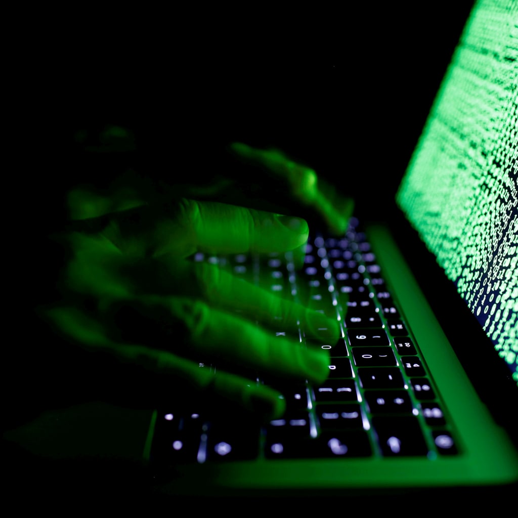 <p>A man types on a computer keyboard in front of the displayed cyber code. </p>
