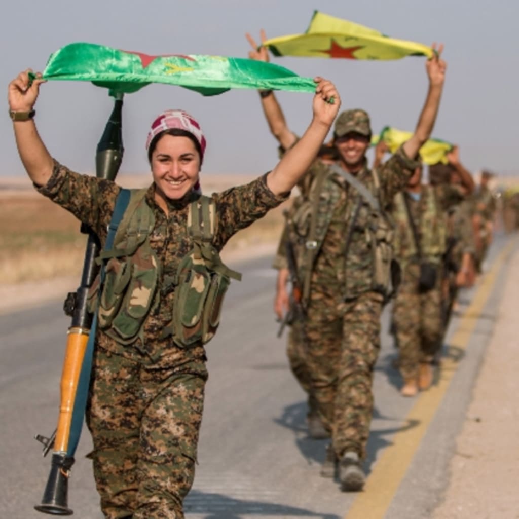 <p>Kurdish fighters gesture while carrying their parties’ flags in Tel Abyad of Raqqa governorate after they said they took control of the area June 15, 2015 </p>
