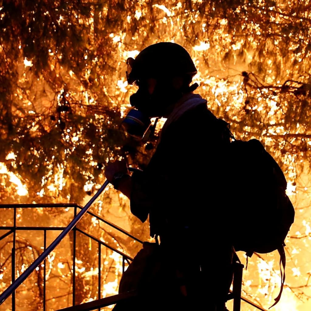 <p>A volunteer sprays water as a wildfire burns near Athens, Greece. </p>

