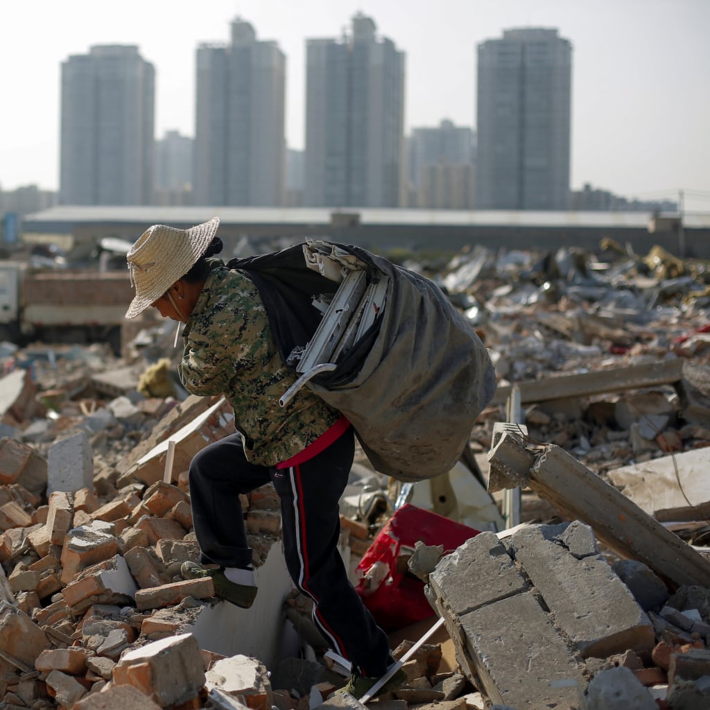 <p>Migrant worker Wang Jun carries scrap material she collected from debris of demolished buildings at the outskirts of Beijing, China October 1, 2017. </p>
