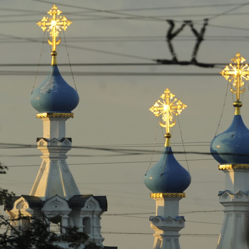 <p>A Russian policeman passes an Orthodox church during a demonstration to support political prisoners in Moscow.</p>
