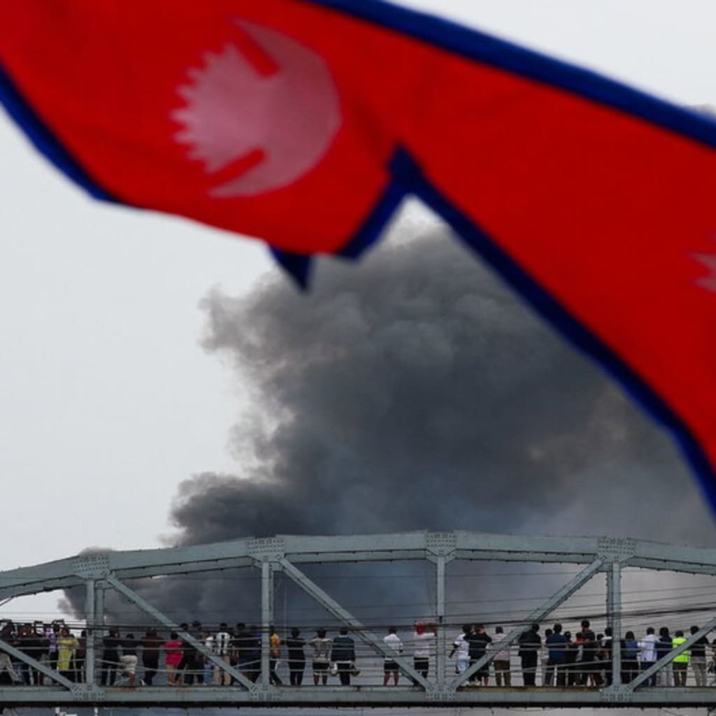 <p>Smoke rises after demonstrators set the main gate of the Parliament on fire, during a protest against Monday’s killing of 19 people after anti-corruption protests that were triggered by a social media ban, which was later lifted, during a curfew in Kathma</p>
