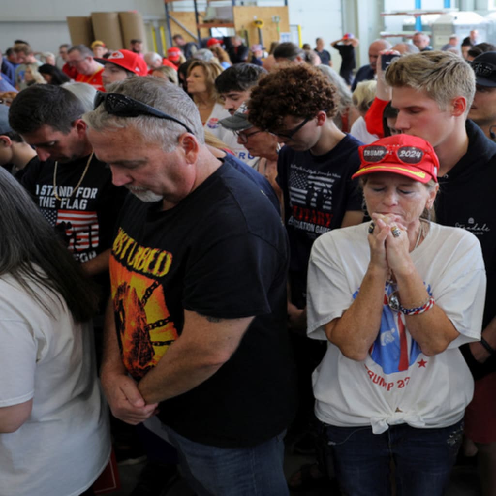 <p>Supporters of Republican presidential nominee and former U.S. President Donald Trump pray during the invocation on the day Trump makes a campaign stop at manufacturer FALK Production in Walker, Michigan, U.S. September 27, 2024.</p>
