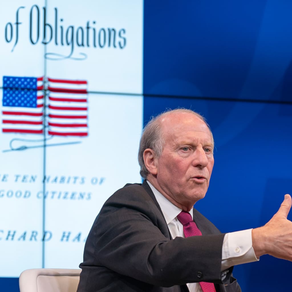 Richard Haass speaks in front of screen showing cover of his new book