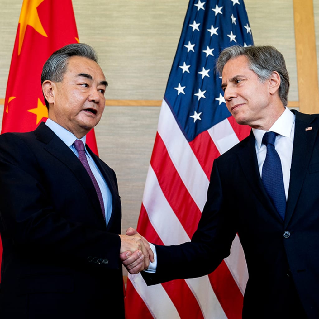 Blinken and Yi shake hands