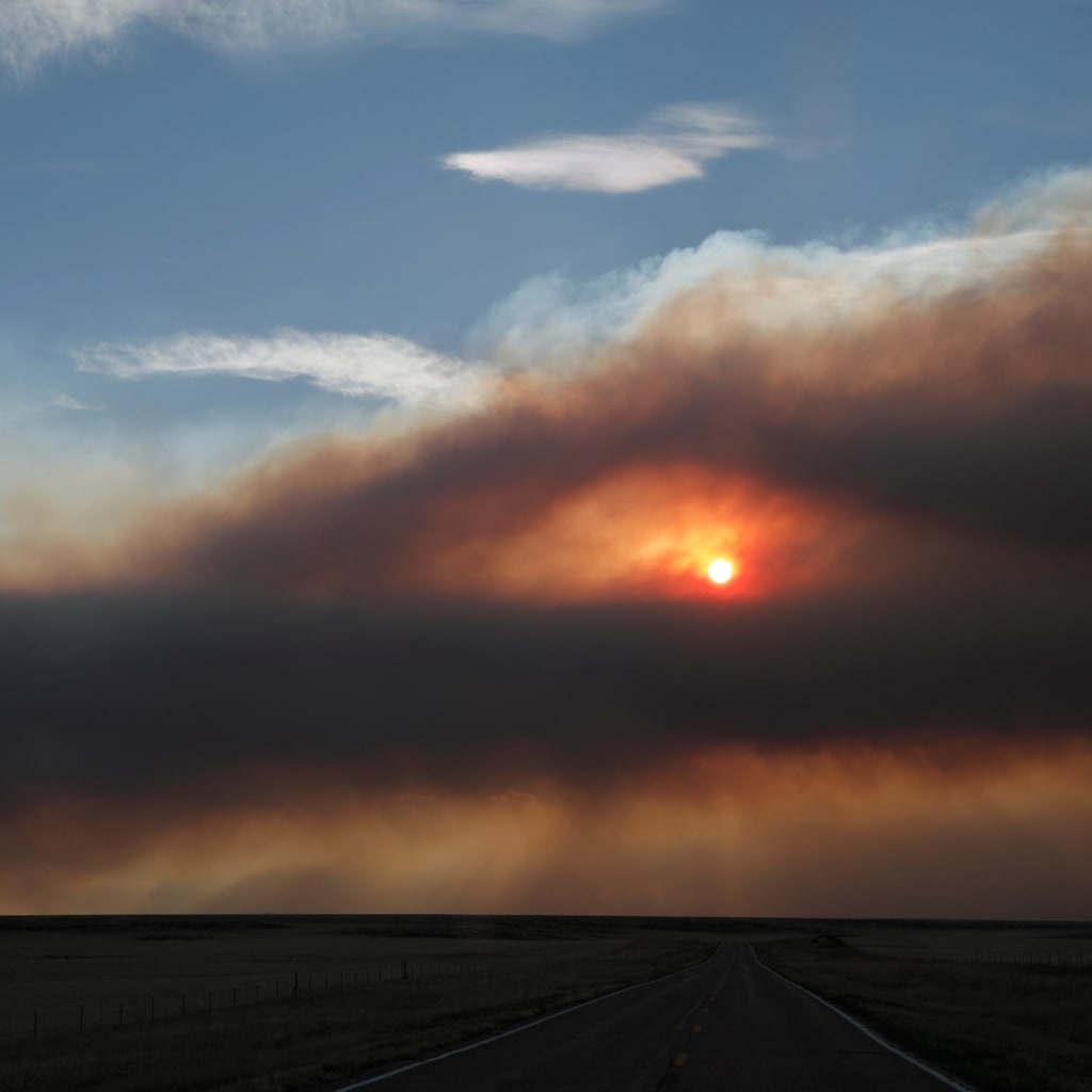 <p>A general view of the landscape with plumes of smoke from the Hermits Peak and Calf Canyon fires filling the sky, near Ocate, New Mexico</p>